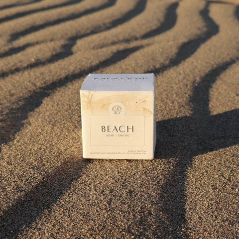 Box labeled 'Beach' on sand with wavy patterns