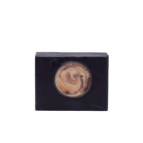 Swirl-patterned soap bar in a black rectangular container on a white background