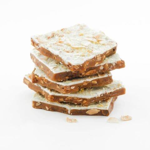 Stack of chocolate-coated toffee pieces on a white background