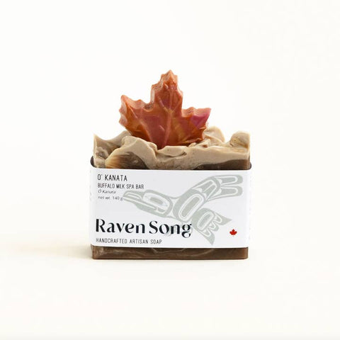 Soap bar with a decorative top featuring a maple leaf, branded 'Raven Song'.