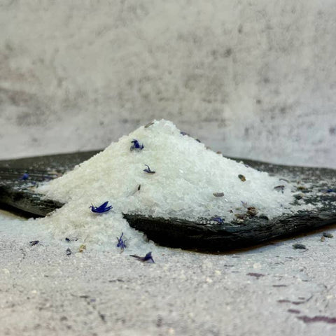 White salt with small blue flowers on a stone surface