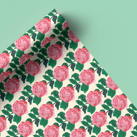 Floral patterned fabric with pink roses and green leaves on a light background