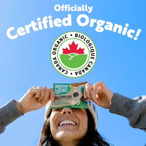 Person holding a certified organic product with a clear blue sky background
