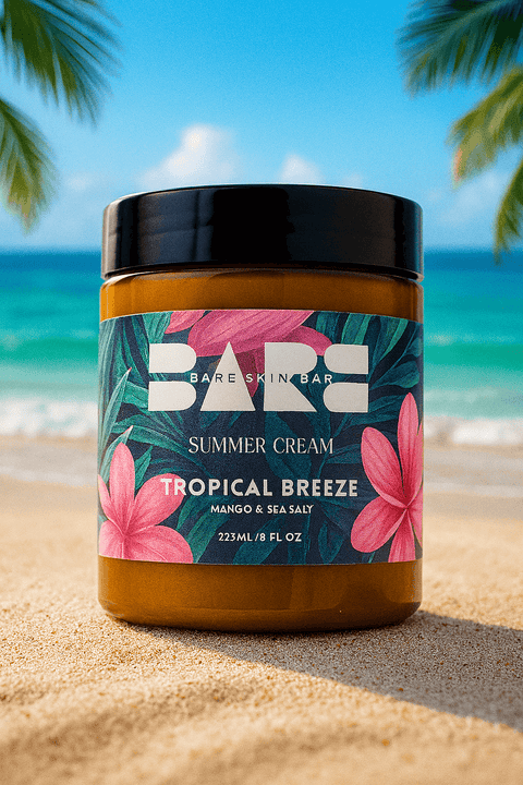 Jar of 'Bare Skin Bar' Summer Cream 'Tropical Breeze' on a sandy beach with ocean and palm trees in the background.