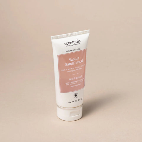Tube of Scentuals Vanilla Sandalwood hand and body repair cream on a beige background