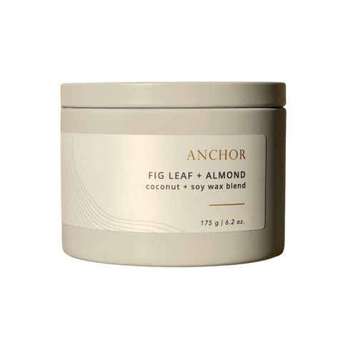Candle jar labeled 'Anchor Fig Leaf + Almond' on a white background