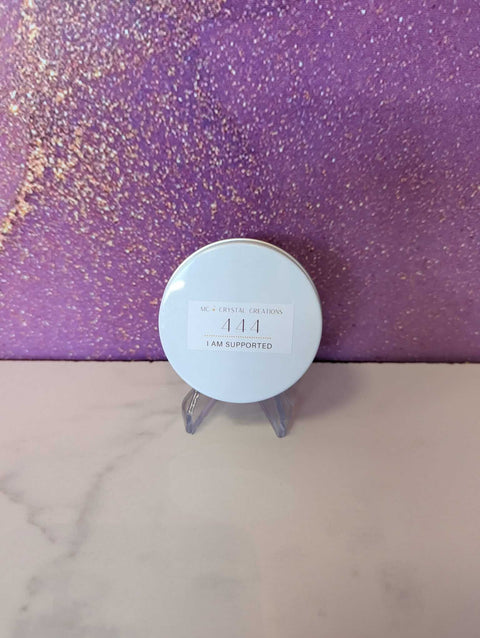 Round white product on a stand with 'I AM SUPPORTED' text against a purple glittery background