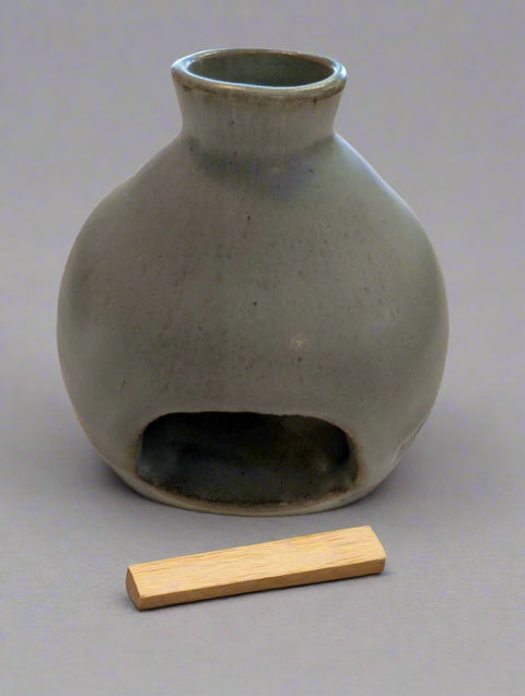 Gray ceramic vase with a small opening on a white background