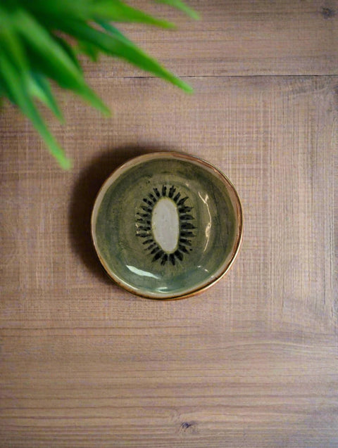 Ceramic plate with a kiwi design on a white surface