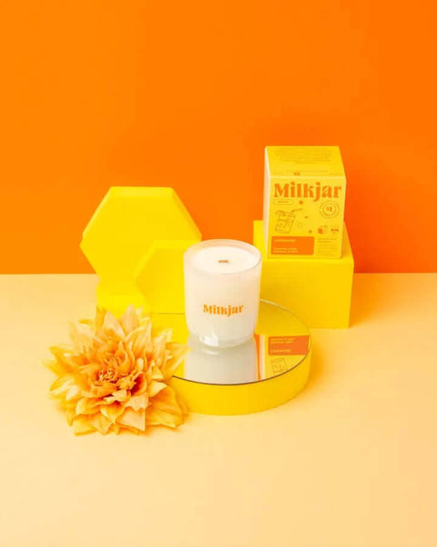 White Milkjar product with yellow packaging and flower on an orange background