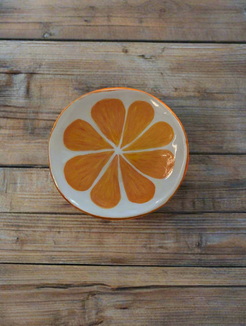 Decorative plate with an orange slice design on a white background