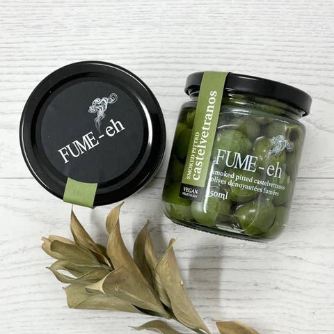 Jar of FUME-eh olives with a black lid and green label on a white background