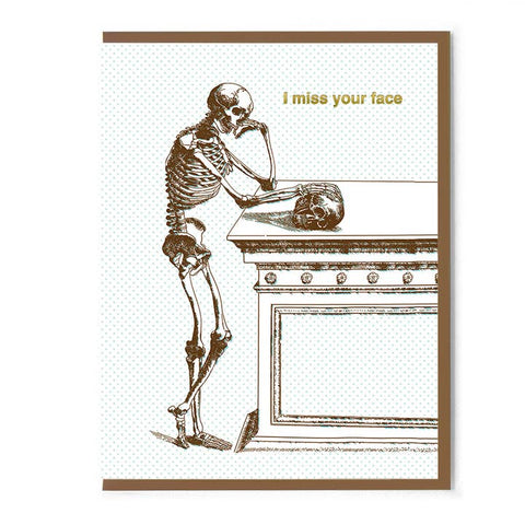 Skeletal figure leaning on a table with 'I miss your face' text on a white background