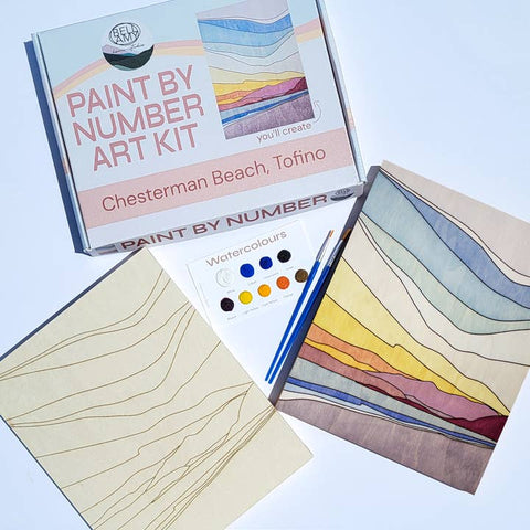 Paint by number art kit with a completed artwork and supplies on a light blue background