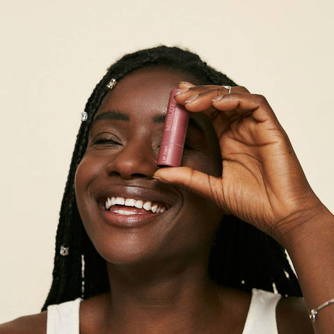 person holding merlot tinted lip balm