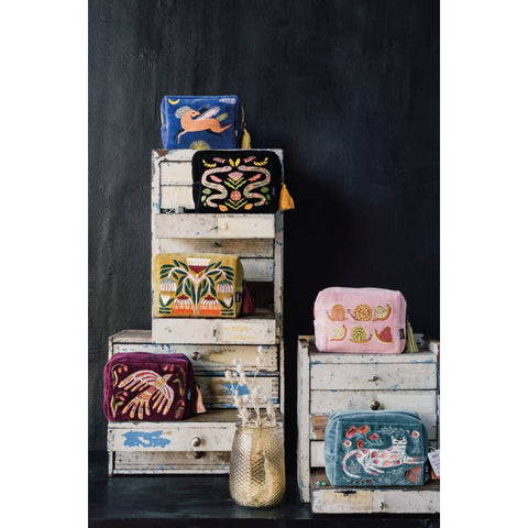 Stack of decorative pouches with various designs on a dark background