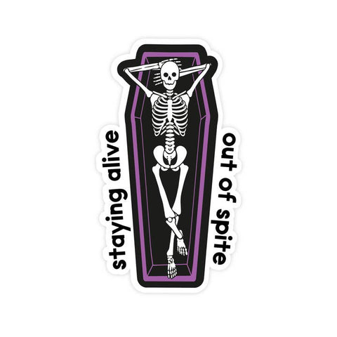 Sticker with skeleton in coffin design and text 'staying alive out of spite' on a white background