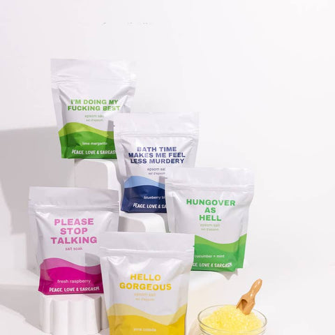 Five bags of bath salts with humorous text labels on a white background