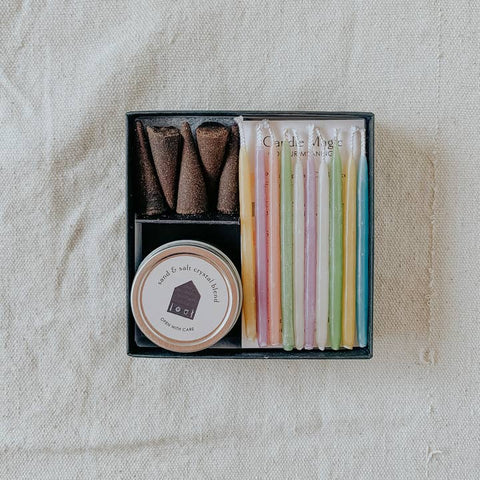 Set of candles in a box on a textured beige surface
