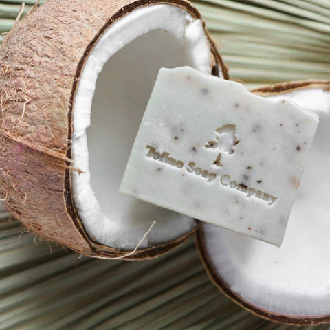 Bar of soap from Tofino Soap Company on a background with a split coconut