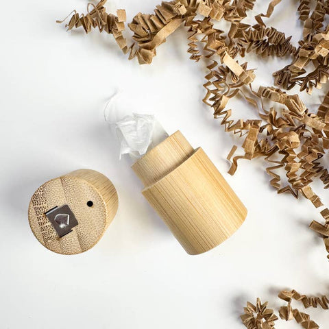 Wooden dental floss diffuser with decorative elements on a light background