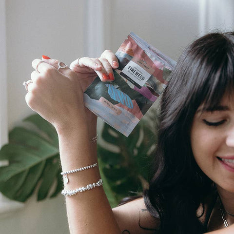 Woman holding a package with a plant in the background