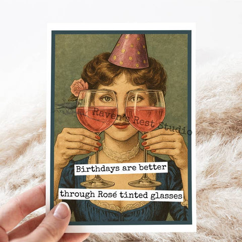 Vintage-style card with a woman holding rose-tinted glasses, featuring the text 'Birthdays are better through Rosé tinted glasses' and 'Raven Rest Studio'.
