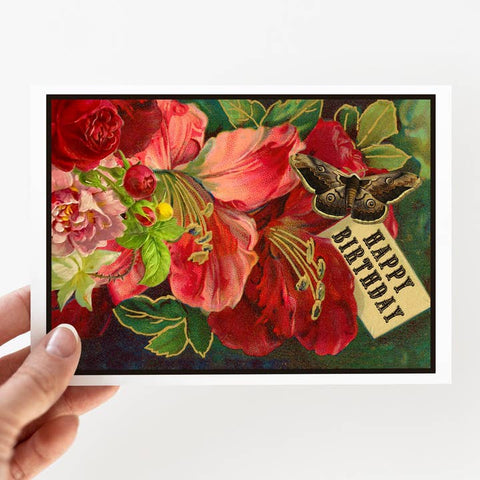 Hand holding a card with floral design and 'Happy Birthday' tag
