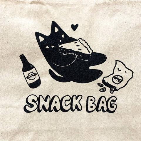 Canvas bag with black illustrations of a cat, bottle, and snacks on a beige background