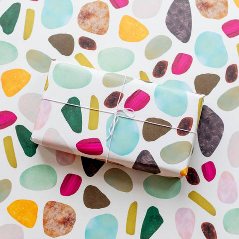 Gift wrapped in colorful abstract pattern paper on a matching background