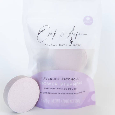 Lavender patchouli shower steamers with packaging on a white background