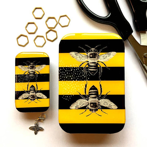 Two small rectangular containers with bee design on a white background