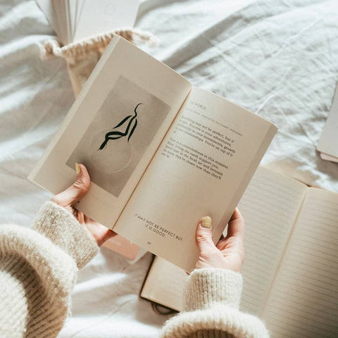 Person holding an open book with a soft focus background