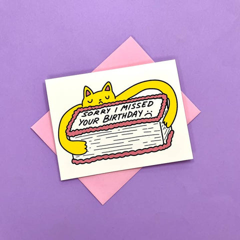 Card with a yellow cat on a cake, apologizing for missing someone's birthday, on a purple background.