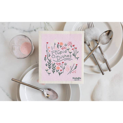 Woven dishcloth with floral design and text on a marble surface with cutlery