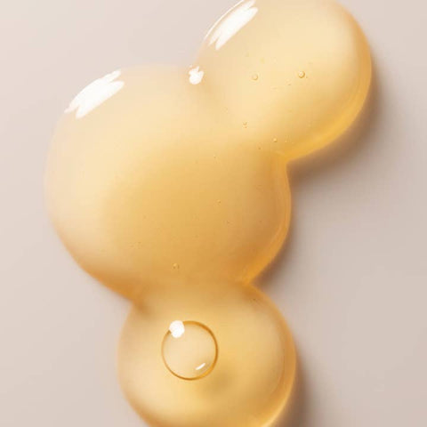 Close-up of a yellow gel-like substance on a light gray background