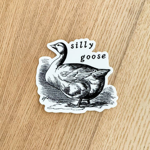 Sticker of a goose with 'silly goose' text on a wooden surface
