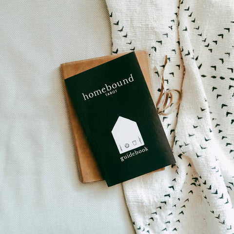 Homebound Tarot guidebook on a textured surface with a white blanket