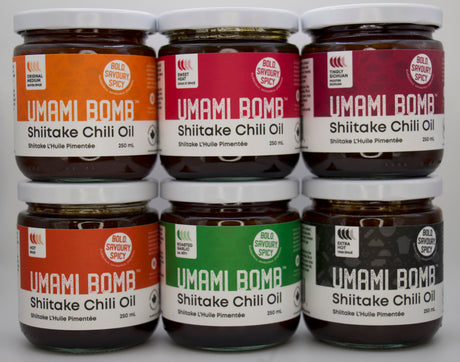 Six jars of Umami Bomb Shiitake Chili Oil on a white background