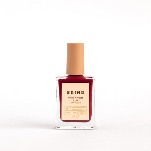 Bottle of BKIND nail polish on a white background