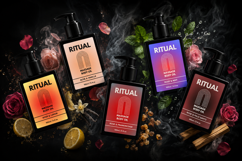 Collection of Ritual massage oils with colorful labels on a dark background with flowers and candles.