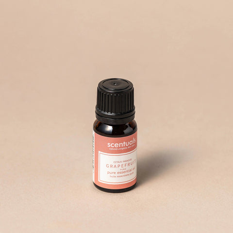 Scentuals grapefruit essential oil bottle on a beige background