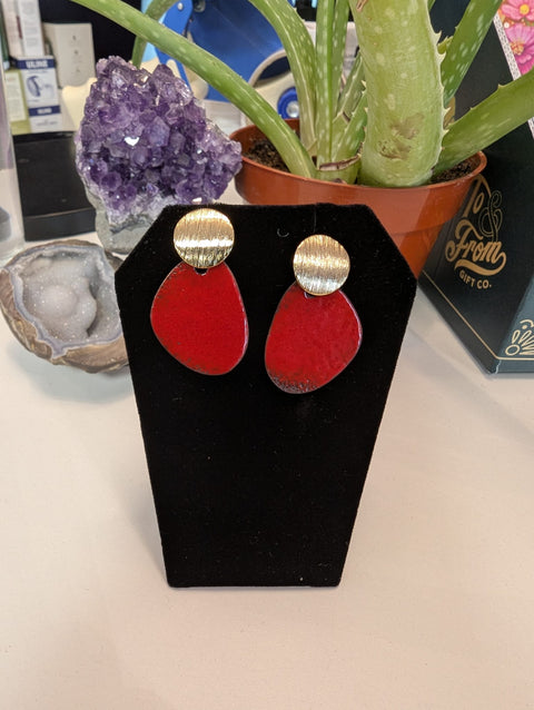 Red earrings on a black stand with a blurred background