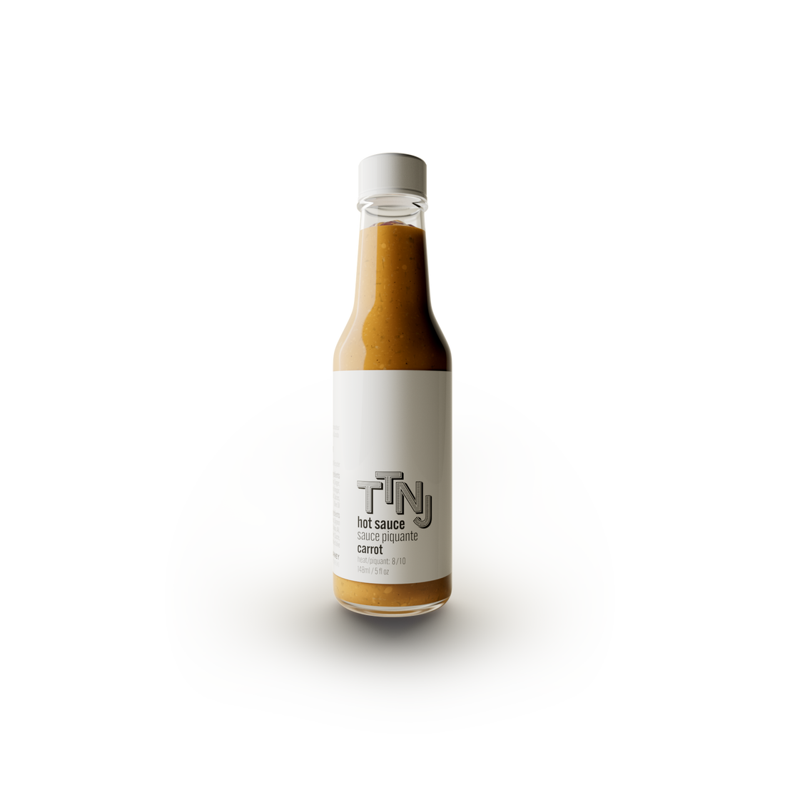 carrot hot sauce by ttnj in glass bottle with white label