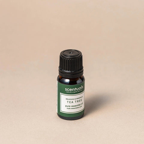 Scentuals Tea Tree essential oil bottle on a beige background