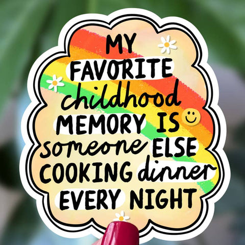 A die-cut sticker with a scalloped cloud outline featuring the text 'MY FAVORITE childhood MEMORY IS someone ELSE COOKING dinner EVERY NIGHT' in black lettering over a pastel rainbow background with small white daisy illustrations.