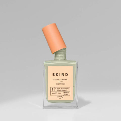 BKind nail polish bottle with orange cap on a gray background
