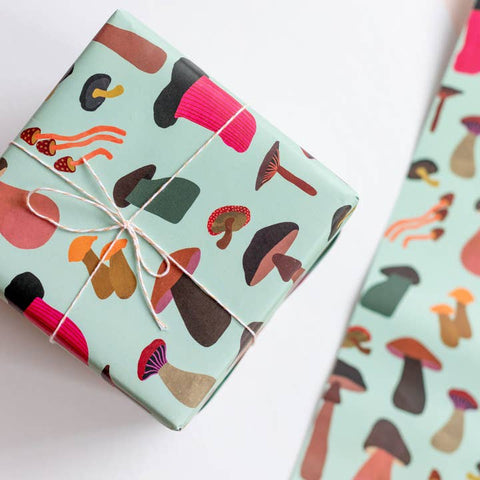 Gift wrapped in colorful mushroom-patterned paper on a white background