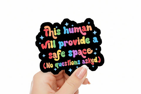 Hand holding a colorful sticker with text on a pink background