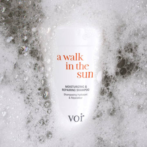 Shampoo bottle labeled 'a walk in the sun' with a soapy texture on the sides.